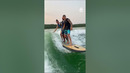 Friends Surf Together On Single Surfboard