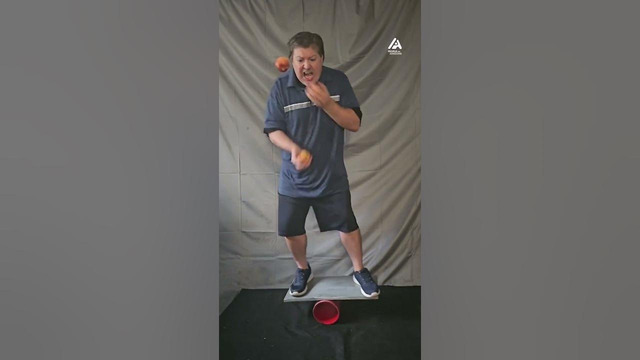 Man Juggles Apples on Balance Board