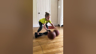 Little Girl Dribbles Two Basketballs While Balancing on Hoverboard