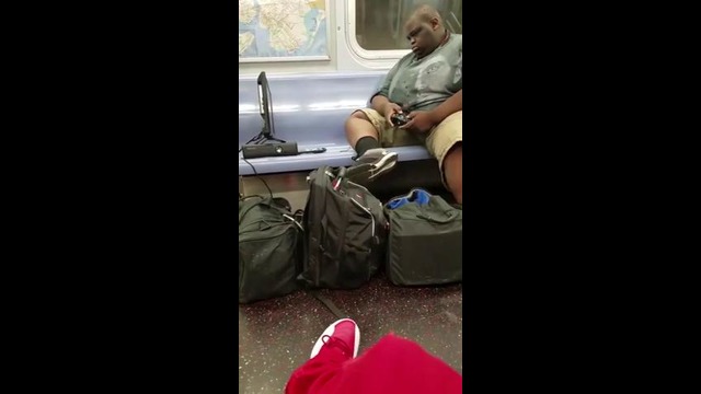 Парень играет в приставку в вагоне метро