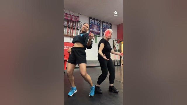 Elderly Woman Performs Zumba Dance With Instructor
