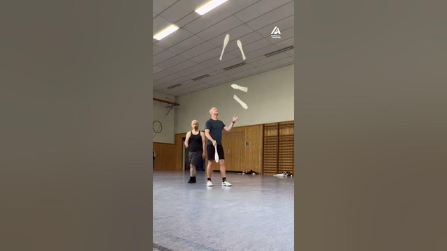 Duo Performs Juggling Trick With Five Clubs
