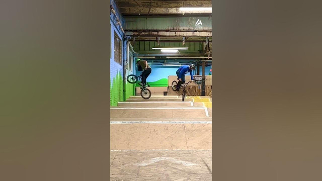 Two BMX Riders Perform Synchronized Spins On Wave Ramp