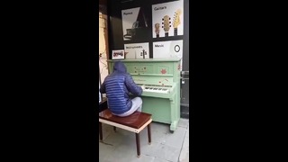 Парень круто играет на пианино на улице