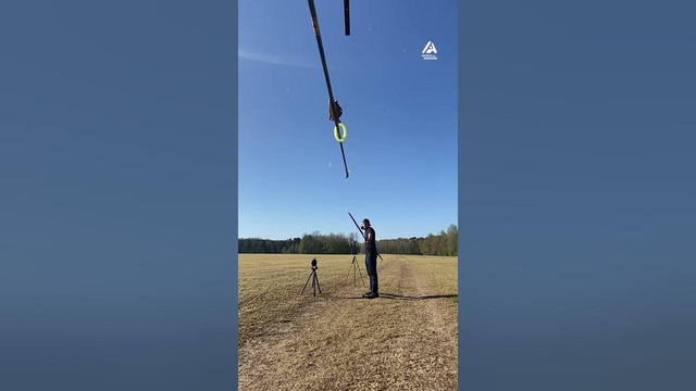 Archer Shoots Arrow Into Horizontally Hanging Pole Through Swinging Ring