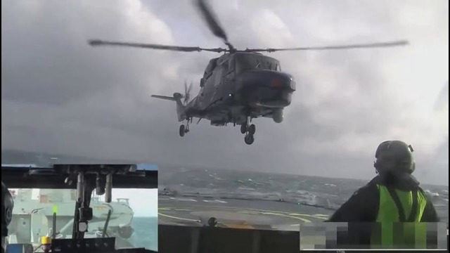 Пилот вертолета садится на палубу при сильной качке и ветре